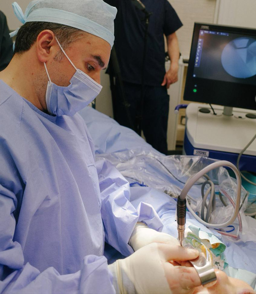 Professor Ali Ghanem performing a precise surgical procedure in a state-of-the-art operating room.
